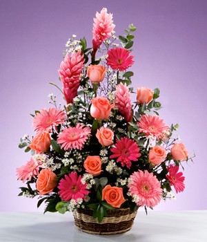 canasta de flores surtidas en tonos rosados